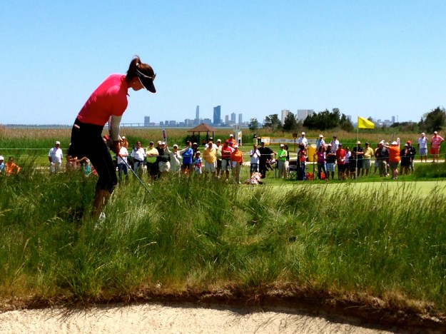 Michelle Wie hitting out of the junk.  Atlantic City skyline behind her